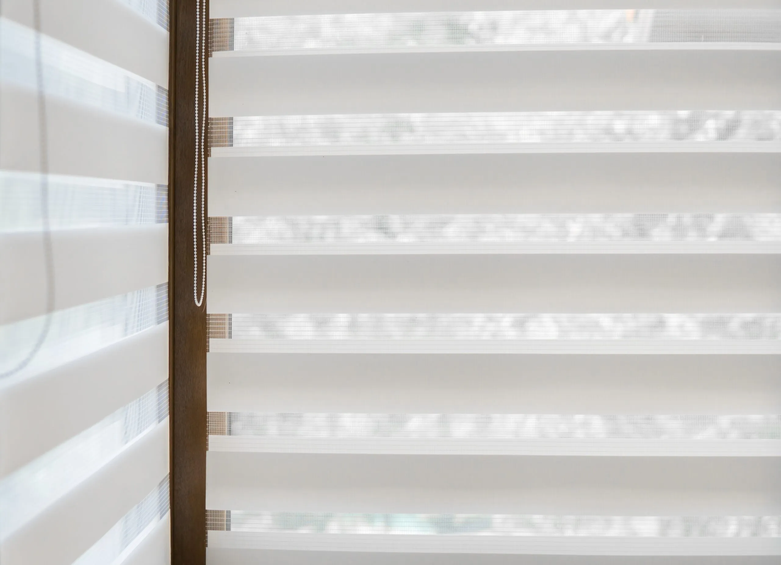 Details Of White Fabric Roller Blinds On The Plastic Window With Wood Texture In The Living Room.